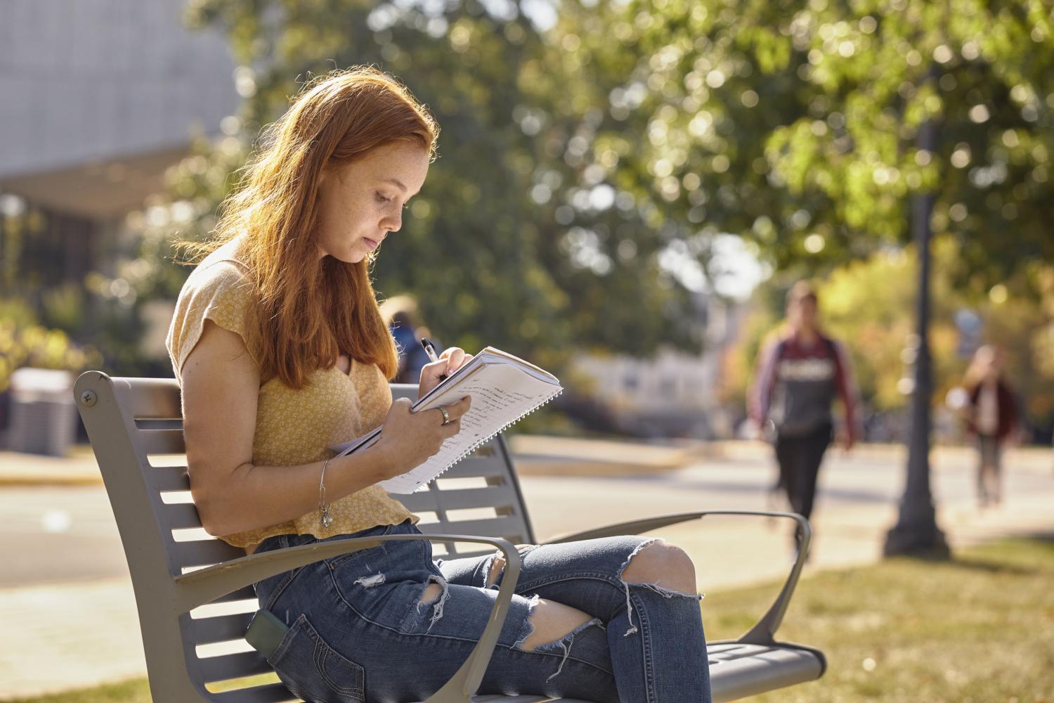一位<a href='http://armada.nkgx.net'>全球十大赌钱排行app</a>学院的学生在校园里的长椅上读书.